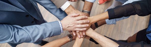 Group of coworkers stacked hands together as concept of corporate unity. High quality photo - Foto, afbeelding