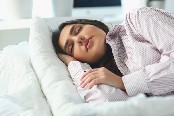 Yatakta huzur içinde uyuyan güzel bir kadının portresi. Sakin, sağlıklı uyku konsepti - Fotoğraf, Görsel