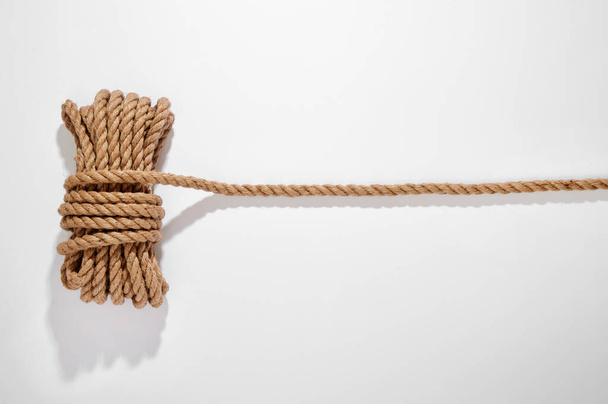 Top view of tied rope placed on white background with shadow in light studio - Фото, изображение