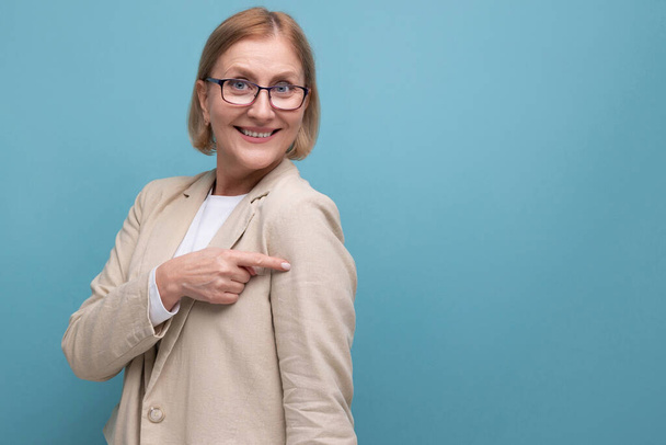 horizontale foto van een succesvolle volwassen zakenvrouw in een klassiek jasje op een heldere achtergrond met kopieerruimte. - Foto, afbeelding