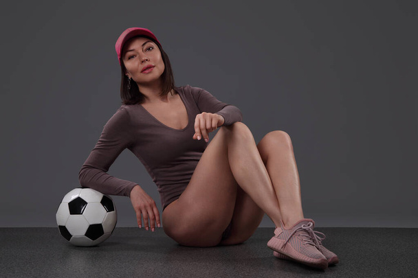 mladá žena s fotbalovým míčem na černém pozadí - Fotografie, Obrázek