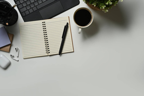 Eenvoudige werkplek met laptop, notitieblok, kopje koffie en oortjes. Kopieer ruimte voor reclame tekst. - Foto, afbeelding