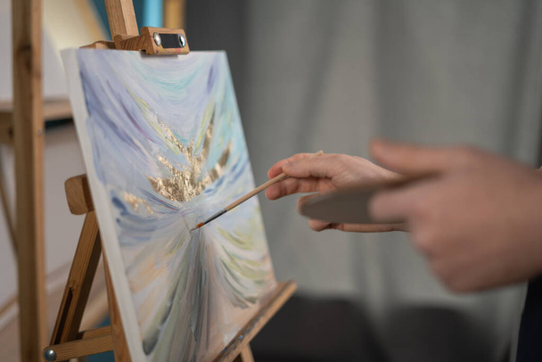 Handen van kunstenaar met penseel en palet schilderij beeld in atelier. Kunst, creativiteit en mensbeeld - Foto, afbeelding