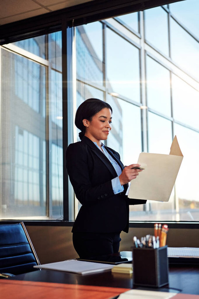 Succes in de maak. een jonge vrouwelijke advocaat staat naast haar bureau in het kantoor - Foto, afbeelding