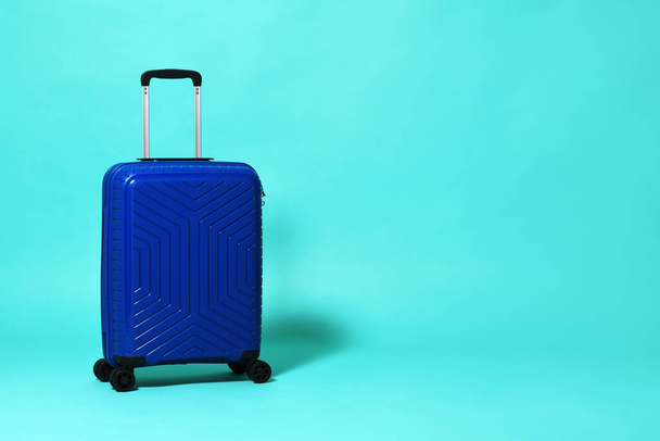 Blue trolley travel bag on mint background - Valokuva, kuva