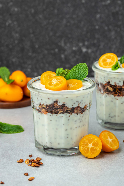 Chia pudding parfait, layered with kumquat and granola. breakfast. Healthy food concept. place for text. - Foto, Imagem