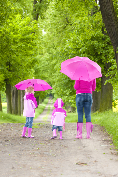Mutter und ihre Töchter mit Regenschirmen - Foto, Bild