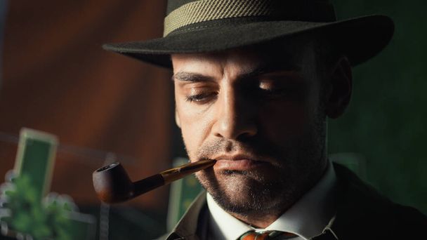 Close up of detective smokes a pipe - Foto, afbeelding