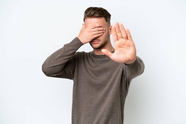 Young blonde caucasian man isolated on white background making stop gesture and covering face - Photo, Image