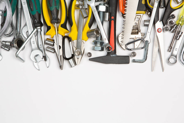 Conjunto de herramientas para la reparación en una caja sobre un fondo blanco. Surtido de herramientas de trabajo o construcción. Llaves, tenazas, destornillador. Vista superior - Foto, imagen