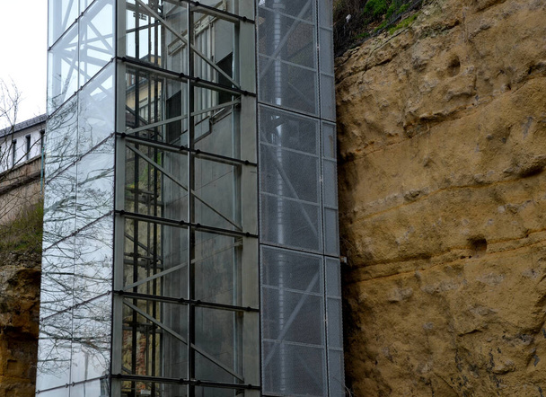 um elevador exterior com uma estrutura de vidro pode ser adicionado a uma casa histórica, onde não é possível realizar trabalhos de demolição. você pode ver a cabine subindo o eixo transparente, rocha, penhasco - Foto, Imagem