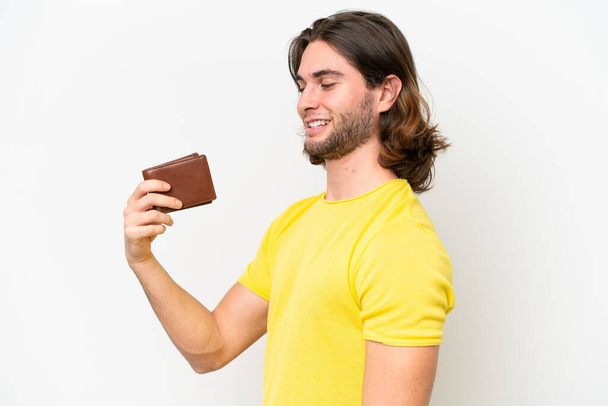 Fiatal jóképű férfi kezében egy pénztárca elszigetelt fehér háttér boldog kifejezés - Fotó, kép