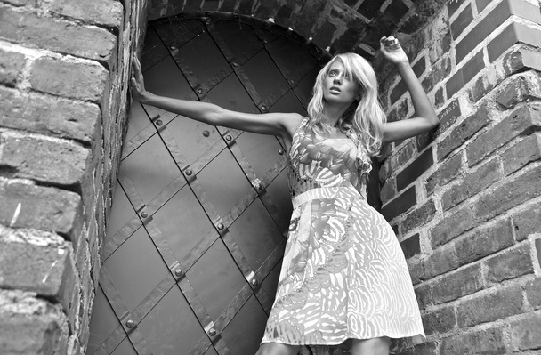 Beautiful young blond woman pose near medieval castle. - Foto, afbeelding