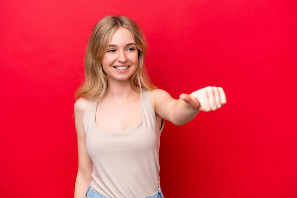 Fiatal angol nő elszigetelt piros háttér ad egy hüvelykujj fel gesztus - Fotó, kép