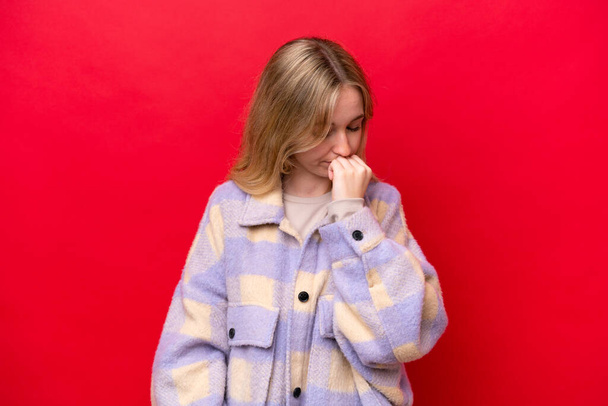 Fiatal angol nő elszigetelt piros háttér kételyek - Fotó, kép