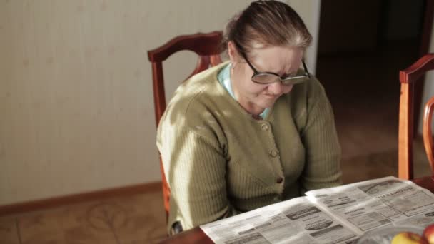 Grandmother reading a newspaper - Materiał filmowy, wideo