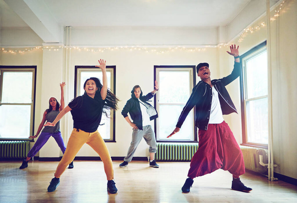 Vien heidän lahjansa studiolle. ryhmä nuoria tanssimassa yhdessä studiossa - Valokuva, kuva