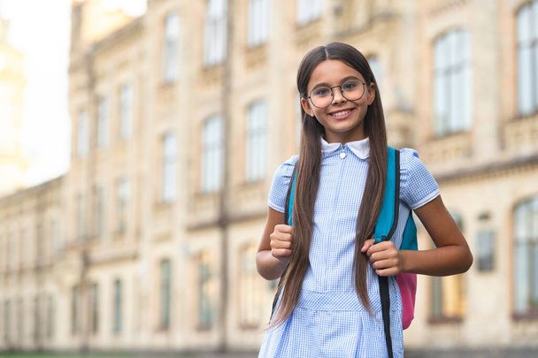 teenage school girl smile outdoor, copy space. photo of teenage school girl. teenage school brunette girl. teenage school girl with backpack. - Фото, изображение