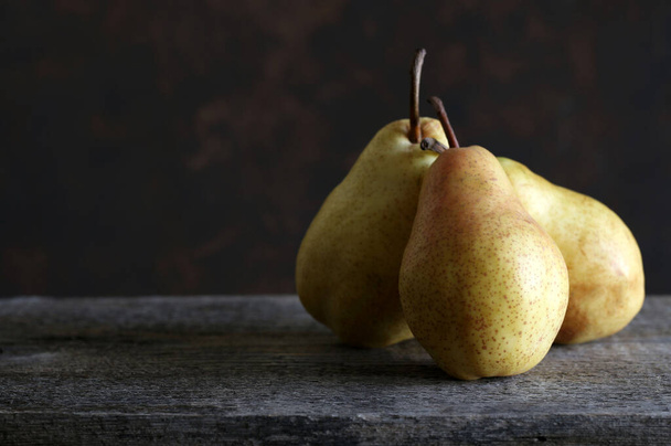 Group of pears isolated on a rustic wooden table. Fresh and Tasty seasonal fruit. Close-up. Copy space. - Fotó, kép