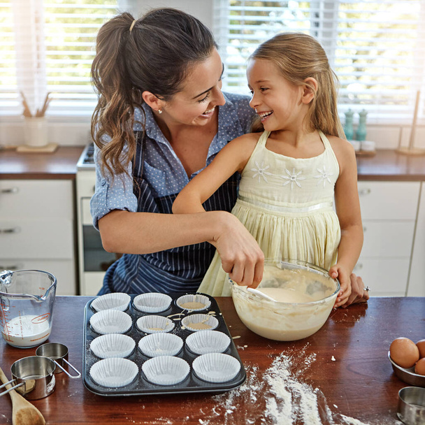 My favorite thing to do is bake with my mom. a mother and her daughter baking in the kitchen - Fotoğraf, Görsel