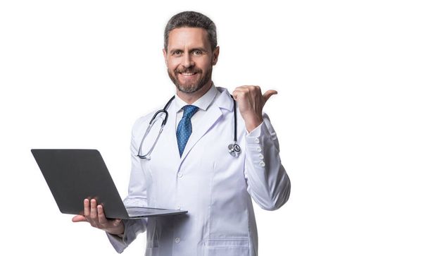 happy doctor promoting ehealth isolated on white. doctor offering ehealth in studio. doctor presenting ehealth on background. photo of ehealth and doctor man with laptop. - Fotó, kép