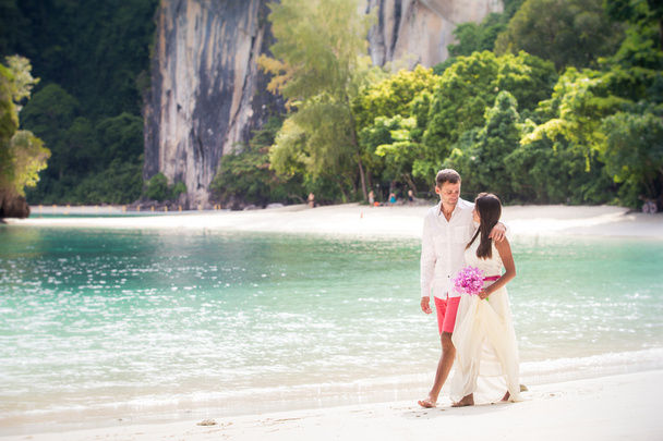 Handsome groom with pretty bride on beach - Photo, Image