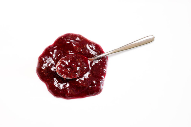 A spoon with strawberry jam sauce isolated on white background. Overhead view. Copy space. - Photo, Image