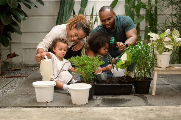 Happy African American family enjoying gardening at home - Foto, afbeelding