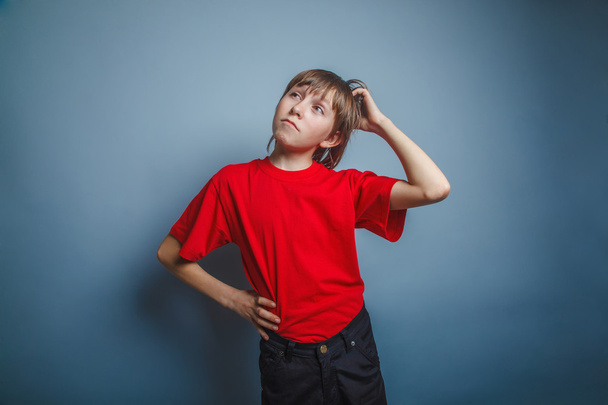 Европейский мальчик лет десять думает, чешет голову
 - Фото, изображение