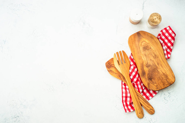 Olive board, utensílios e toalha de mesa sobre mesa de cozinha branca. Fundo alimentar com espaço de cópia. - Foto, Imagem