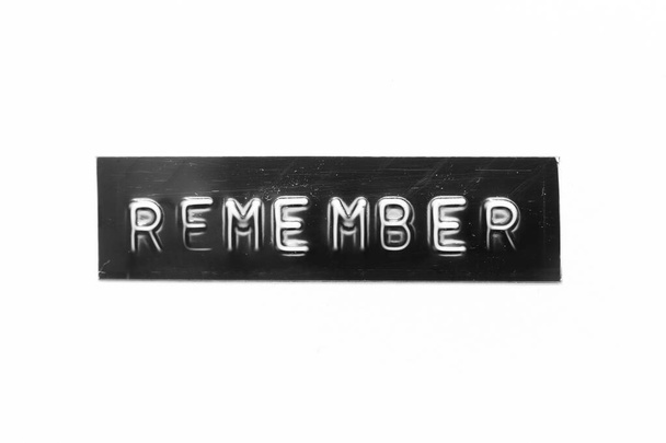 Banner de color negro que ha grabado la letra con la palabra recordar en el fondo de papel blanco - Foto, imagen