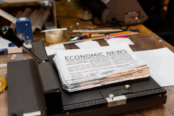 newspapers with economic news inside of professional paper trimmer - Photo, Image