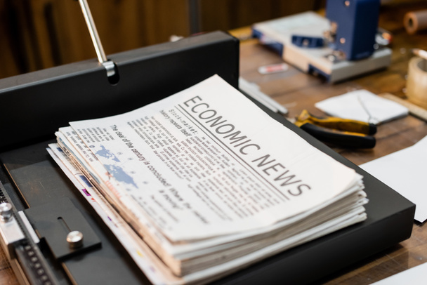 печатные газеты с экономическими новостями внутри профессиональной машины для обрезки бумаги  - Фото, изображение