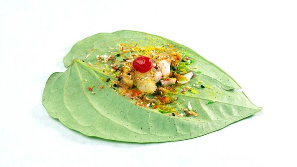 Hoja de betel dulce comestible verde aislada sobre el fondo blanco. La hoja fresca de betel es popular en el festival cultural del sudeste asiático. las especias son coco, cereza, comino, cilantro, bola dulce etc.. - Foto, Imagen