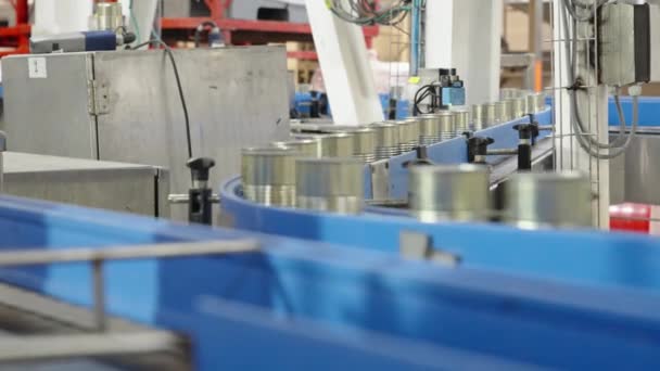Latas de salsa de tomate en una cinta transportadora rápida en una planta de producción de alimentos enlatados - Metraje, vídeo