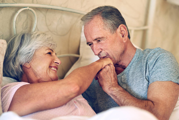 Time has no effect on true romance. a senior couple being affectionate in their bedroom - Foto, imagen
