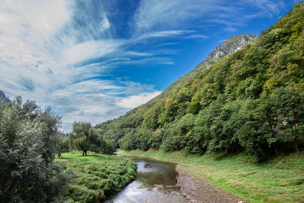 Panorama doliny rzeki Cerny, zwanej Valea Cerna, z panoramą gór Mehedinti, niedaleko Baile Herculane, w Rumunii, w Karpatach. - Zdjęcie, obraz