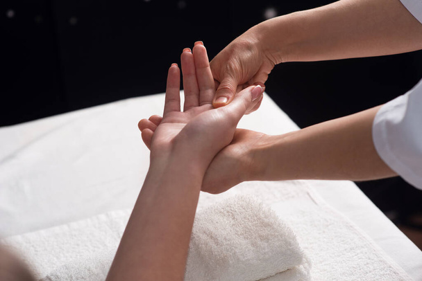 Masseur doing hand massage with oil in spa salon. Spa procedures. relaxing, wellness hand massage. Body care concept. Close-up view. Female hand close-up - Foto, afbeelding