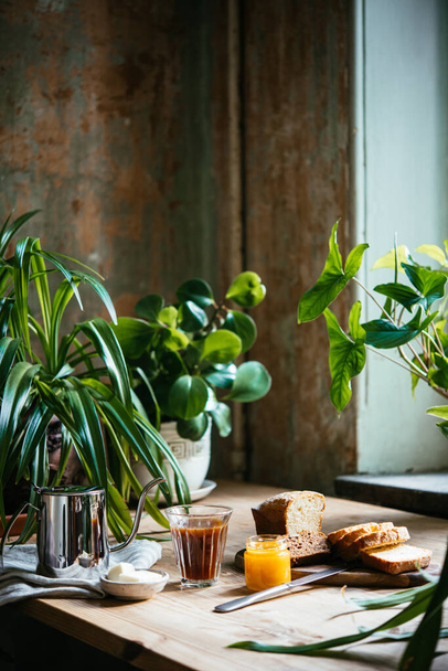 Breakfast with croissants and coffee served at a beautiful table full of plants. Enjoying time at home concept. - Foto, imagen