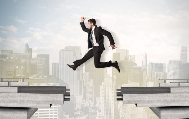 Energetic business man jumping over a bridge with gap - Фото, изображение