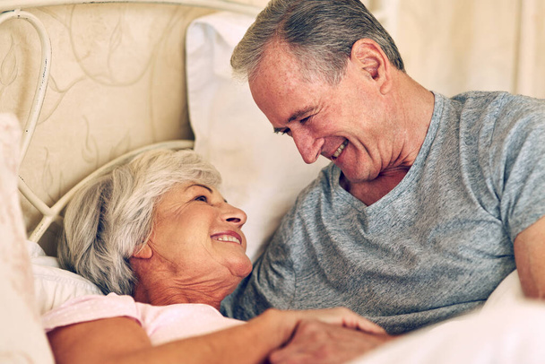 True love only gets stronger with time. a senior couple being affectionate in their bedroom - Foto, Bild