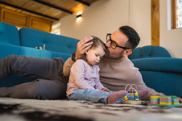 Father and daughter play on the floor at home mature adult caucasian man play with his two years old child toddler girl having fun parenting and bonding family time concept copy space real people - Photo, image