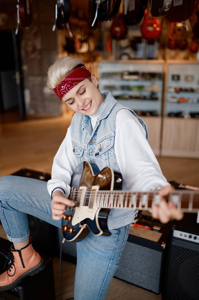 Hipster donna che suona la chitarra collegata al suono stereo amplificatore sensazione di soddisfazione e ammirazione del suono - Foto, immagini