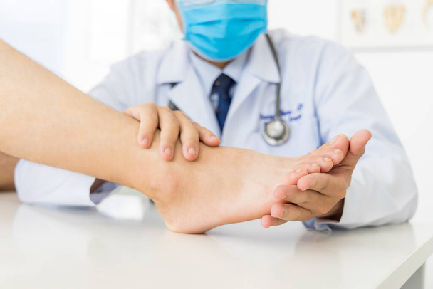 The orthopedic doctor or surgeon in white gown examined the patient with foot pain problem.White clean table or bed with blur background.Hallux or bunion with transfer metatarsalgia.Orthopaedic unit. - Фото, изображение