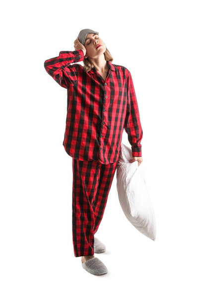 Young woman in checkered pajamas with pillow on white background - Fotografie, Obrázek