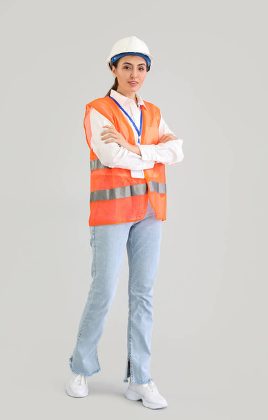 Female worker in vest on light background - Фото, зображення