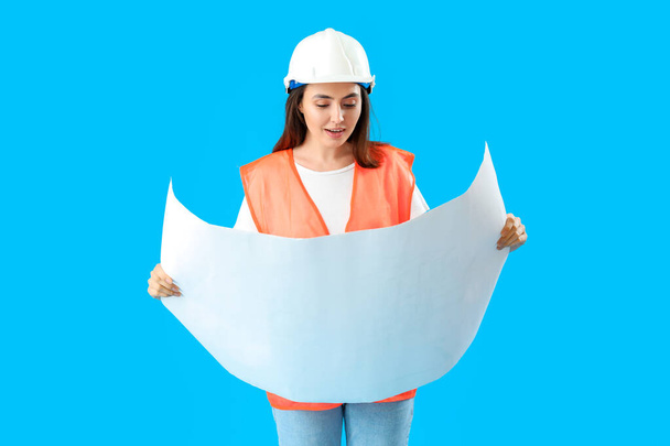 Female engineer with drawing on blue background - Foto, immagini