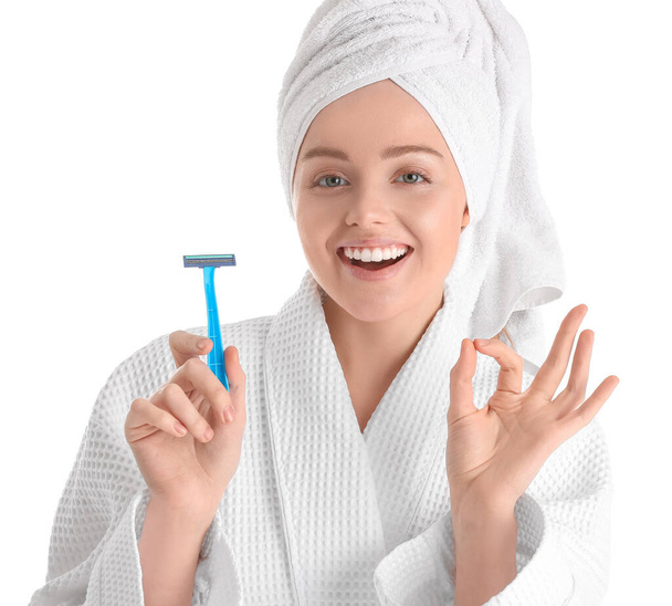 Young woman with razor showing OK on white background, closeup - Photo, image