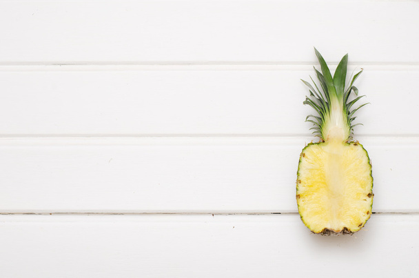 Yksinäinen ananas valkoisella puulla
 - Valokuva, kuva