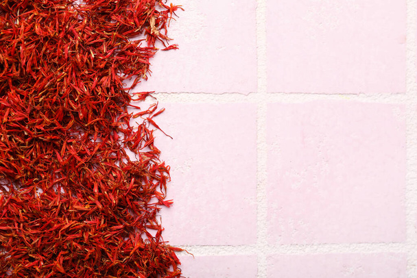 Stapel saffraan op roze tegelachtergrond - Foto, afbeelding